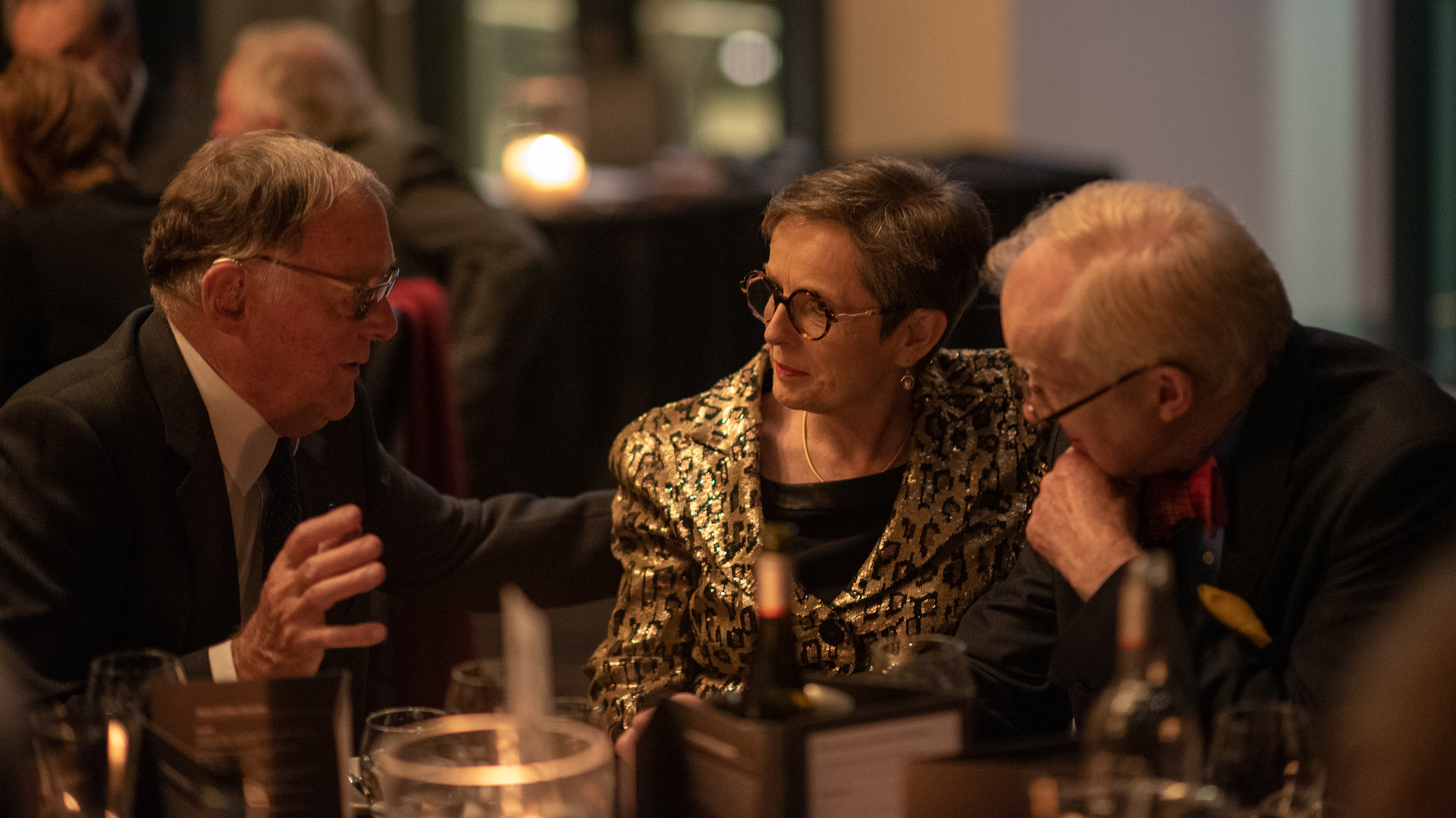 A trio of Opera lovers deep in discussion over dinner
