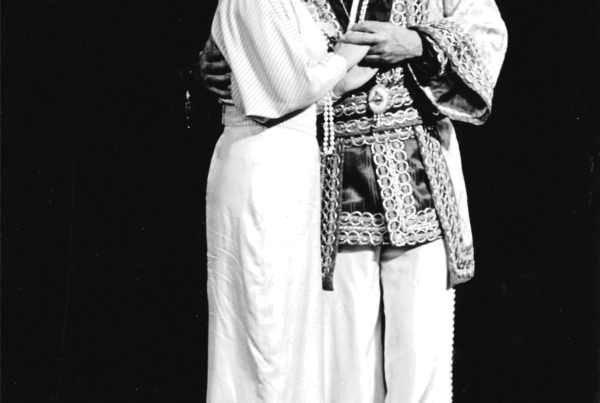 The man and woman embrace as they sing out together to the audience.